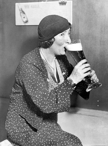 Mujer bebiendo de un gran vaso de cerveza
 - Foto, Imagen