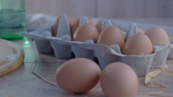 Chicken eggs in the package on a wooden table. - Video