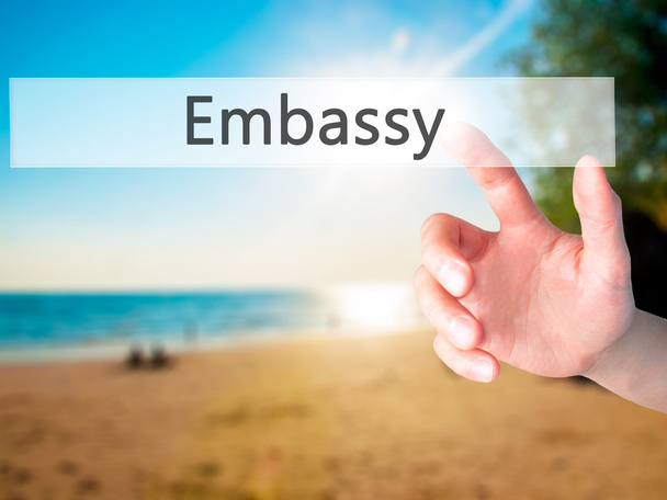 Embajada - Mano presionando un botón sobre el concepto de fondo borroso o
 - Foto, Imagen