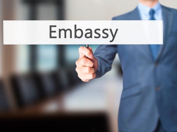 Ambassade-zakenman hand holding teken - Foto, afbeelding