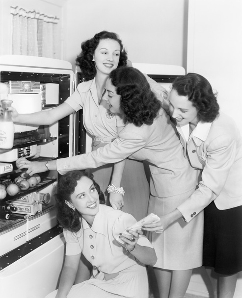 Négy nő vesz dolgokat a hűtőből - Fotó, kép