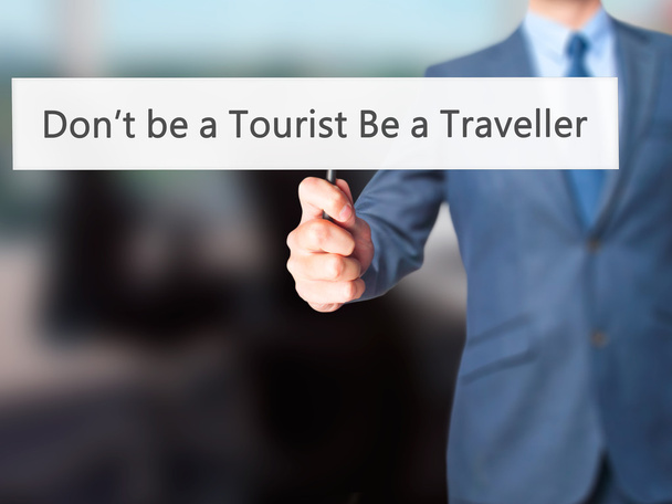 Não seja um turista Seja um viajante Empresário mão segurando sig
 - Foto, Imagem