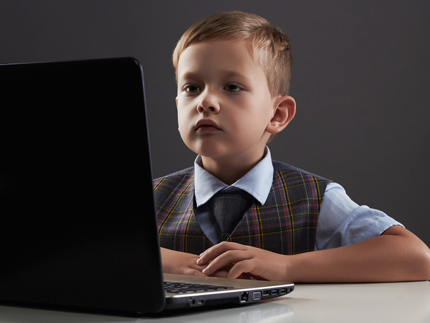 Niño mirando en la pantalla del cuaderno. niño divertido con computadora
 - Foto, Imagen