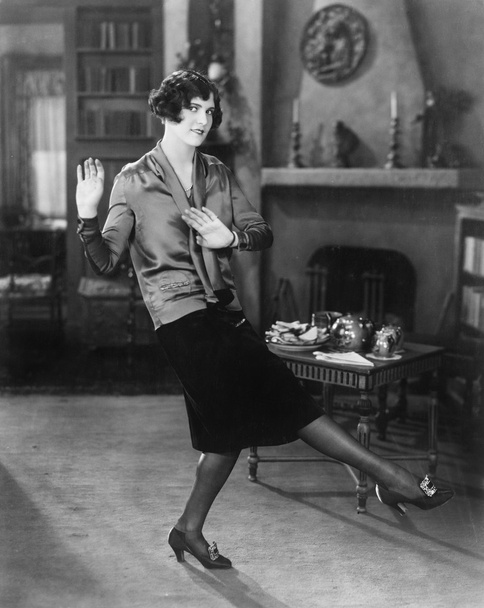 Fiatal nő táncol a nappaliban - Fotó, kép