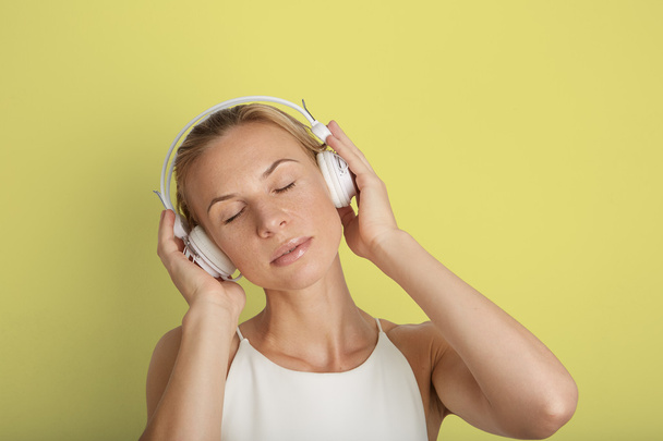 Portrait Handsome Young Woman Listening Headphones Music Player Blank Yellow Color Background.Pretty Girl Enjoy Audio Smiling Hands Up.Beauty Lifestyle Fashion Hipster People Abstract Concept. - 写真・画像