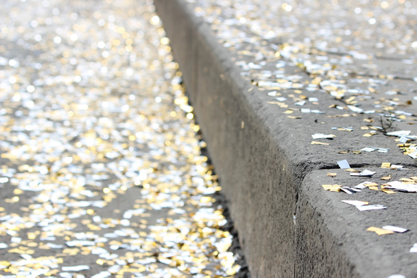 Festival-Hintergrund mit goldenen und silbernen Pailletten, die auf dem Pflaster der Straße liegen Bokeh. - Foto, Bild
