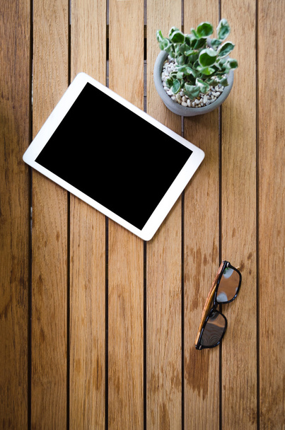 tableta en blanco en escritorio de madera con gafas de sol
 - Foto, imagen