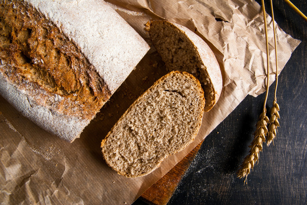 Pachnący świeżo upieczonego chleba żytniego na czarny drewniany stół - Zdjęcie, obraz