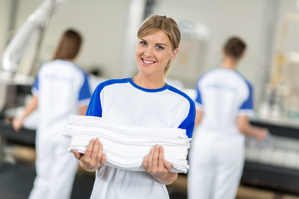 Smiling employed holding clean and ironing textiles - Photo, Image