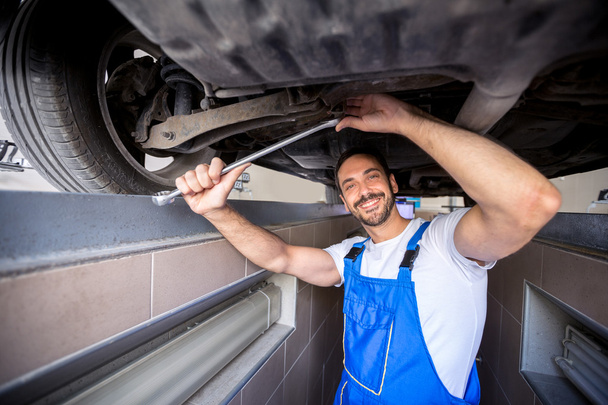 Happy mechanic under car - Фото, изображение