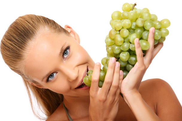 Closeup portrait of a beautiful woman bites in grape - Foto, afbeelding