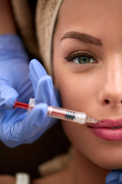Woman receiving injection in lips - Foto, immagini