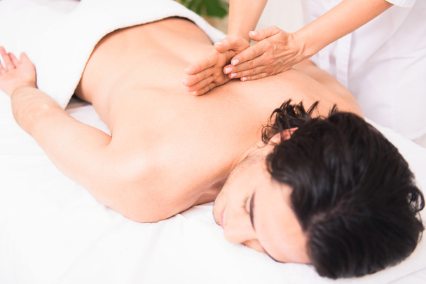 Skillful beautician massaging male back - Foto, imagen