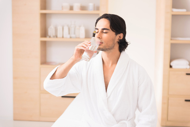 Tranquil guy is thirsty after massage - Fotoğraf, Görsel