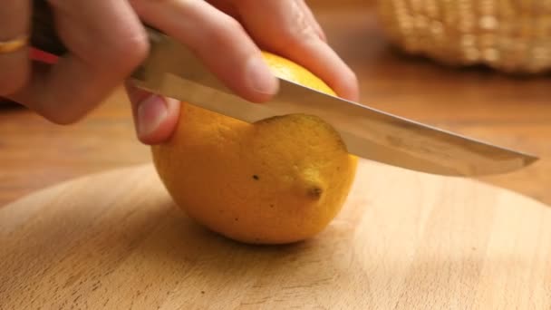 Someone cutting a lemon on the wood board - Кадри, відео