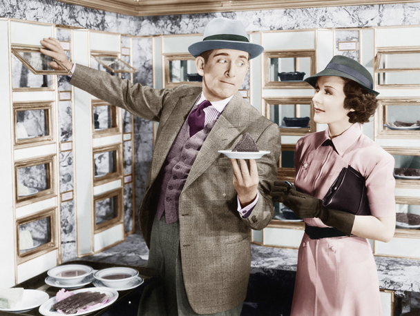 Mann serviert einer Frau in einem Automaten ein Gericht - Foto, Bild