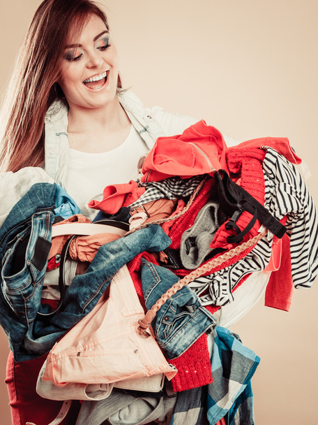 Smiling girl hold pile of clothes. - Foto, Imagen