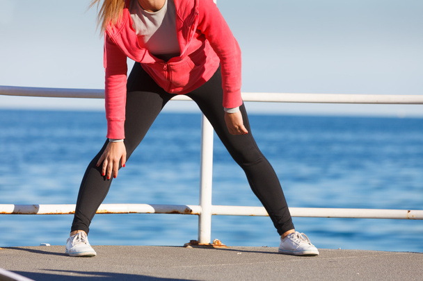 Woman doing sports exercises outdoors by seaside - 写真・画像
