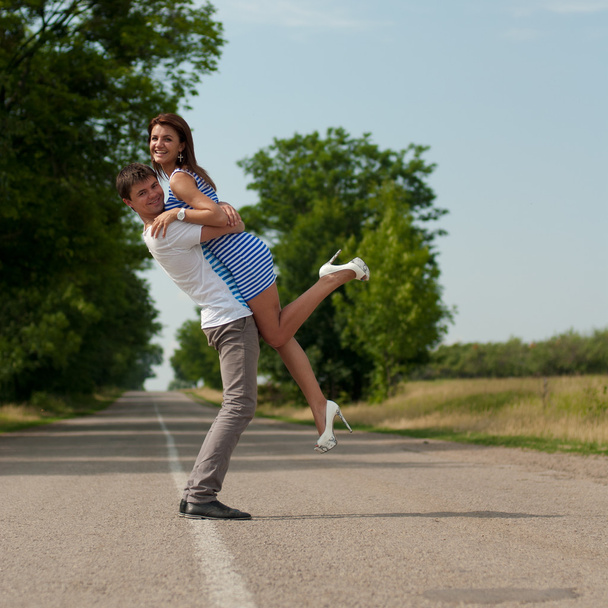 Young happy couple walking along the road - Photo, Image