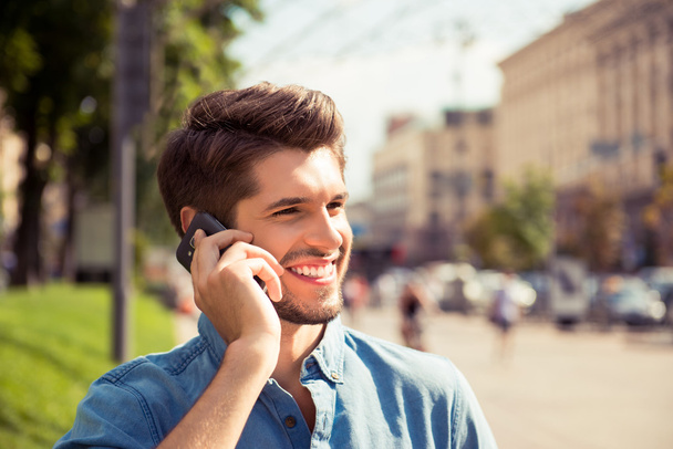 Close up portrait of a handsome man talk on phone and walk stree - Foto, imagen
