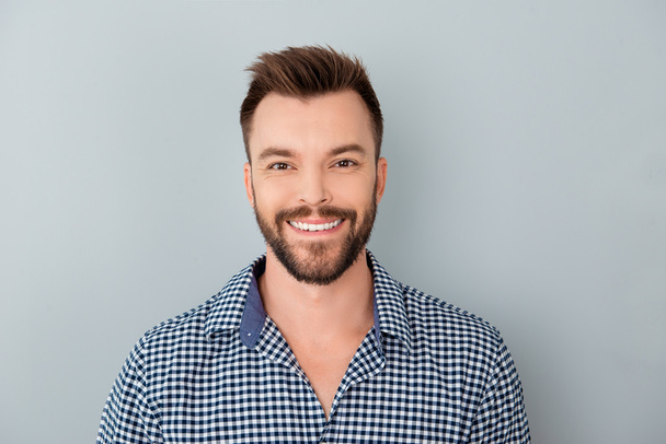 Portrait of cheerful happy bearded young man on gray background - Foto, afbeelding