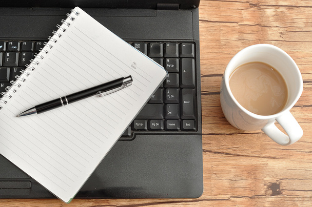 Laptop con un cuaderno y una pluma y una taza de café
 - Foto, Imagen