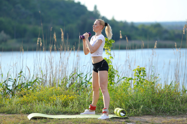 Sporcu kadın ağırlıklı kol bacak egzersiz outdors - Fotoğraf, Görsel