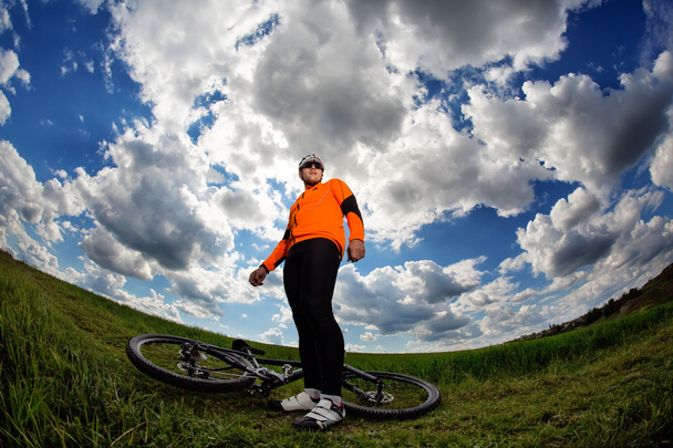 Radfahrer in roter Sportausrüstung und Helm - Foto, Bild