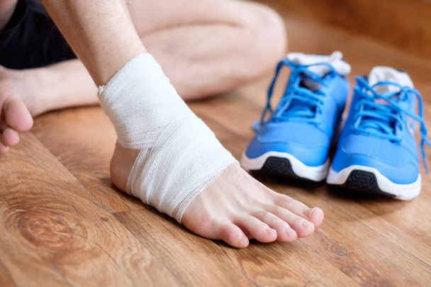 スポーツマンがスポーツ事故の後彼の負傷した足首をマッサージ - 写真・画像