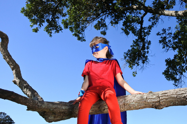 Superhero lány ül egy fa - Fotó, kép