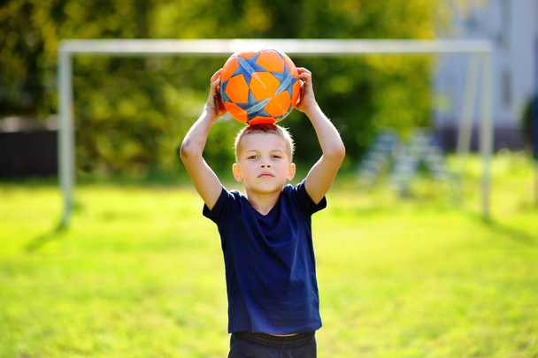 Little boy playing a soccer game on summer day - Фото, изображение