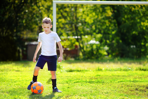 Little boy playing a soccer game on summer day - 写真・画像
