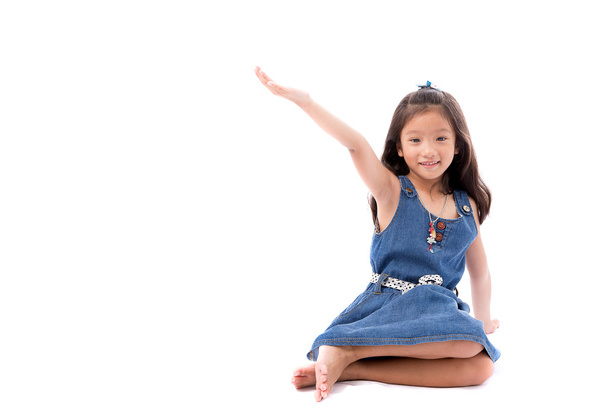 kleine asiatische Mädchen posieren Stretch Hand nach oben isolate auf weißem Hintergrund - Foto, Bild