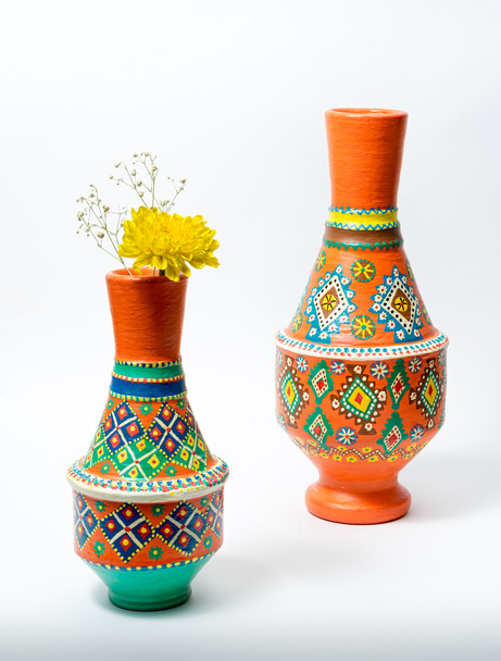 Две разноцветные вазы из керамики с желтым цветком на белой спинке
 - Фото, изображение