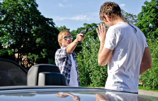 bandita s pistolí ohrožující mladý muž do auta - Fotografie, Obrázek