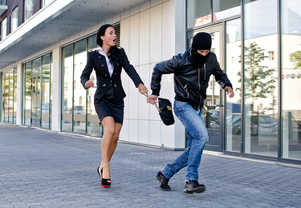 Bandido robando bolsa de mujer de negocios en la calle
 - Foto, Imagen