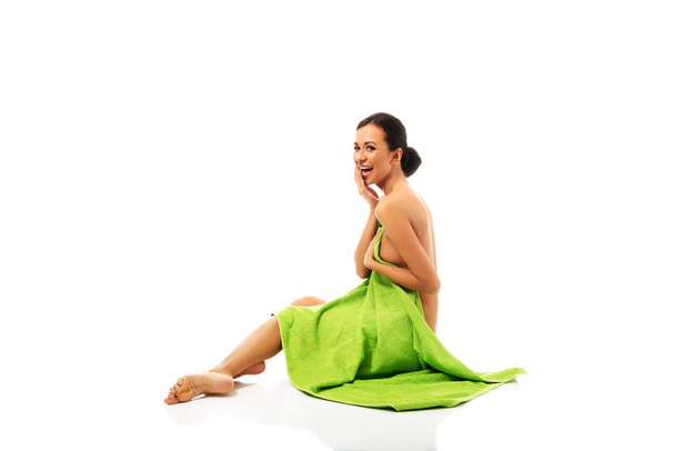 Laughing woman sitting wrapped in towel - Photo, Image