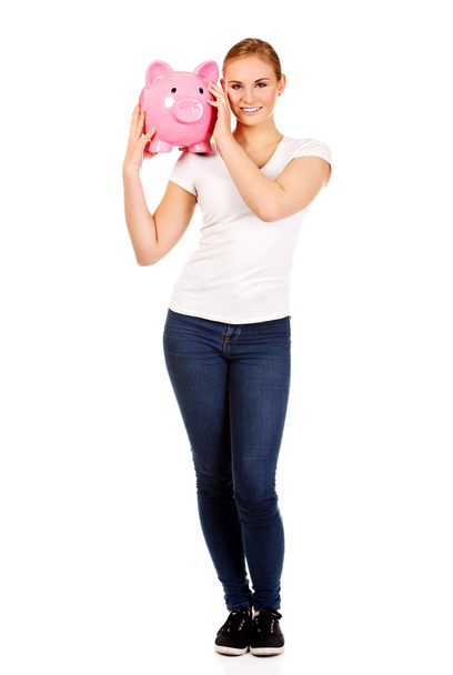 Happy young woman holding piggybank - 写真・画像