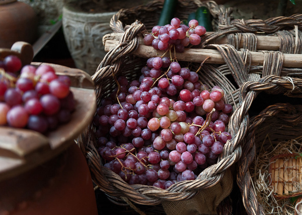 çeşitli demet hasır sepet üzerinde kırmızı üzüm - Fotoğraf, Görsel