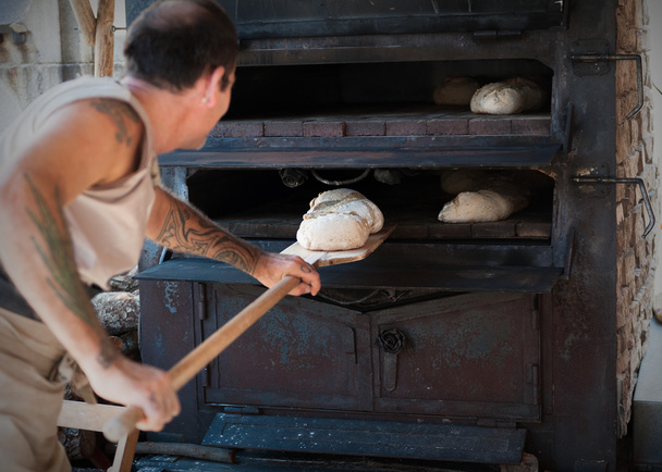 introducir masa de panadero artesanal en el horno
 - Foto, Imagen