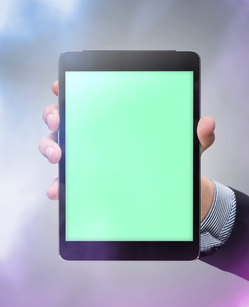 Чоловіча рука тримає макет планшета на кольоровому фоні
 - Фото, зображення