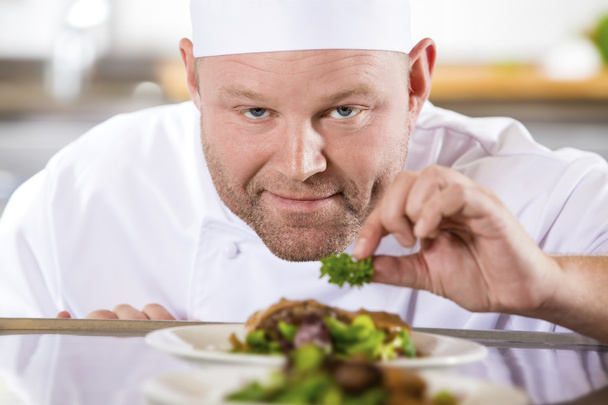 Close-up van de chef-kok glimlachend bereiden biefstuk gerechten in restaurant - Foto, afbeelding