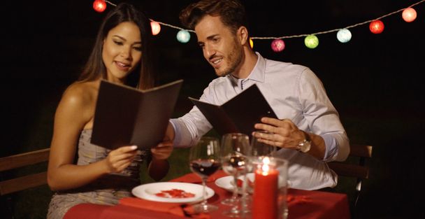 Amar jovem casal escolher comida fora de um menu
 - Foto, Imagem