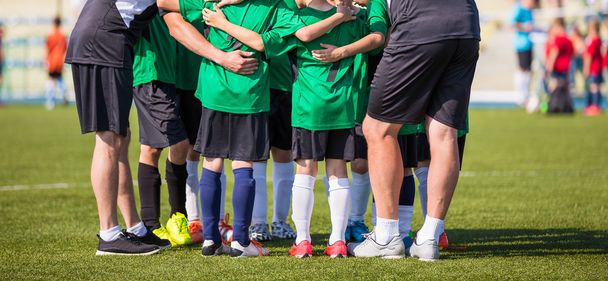 Ποδοσφαιρικό αγώνα ποδόσφαιρο για τα παιδιά. Προπονητής δίνει νέους ποδόσφαιρο ομάδα οδηγίες. Ομάδα νέων ποδοσφαίρου μαζί πριν από το τελευταίο παιχνίδι. Ποδοσφαιρικό αγώνα για τα παιδιά. Αγόρια φωνάζουν ομάδας, τη συγκέντρωση. Προπονητής ενημέρωση. Ποδόσφαιρο Ποδόσφαιρο φόντο. - Φωτογραφία, εικόνα