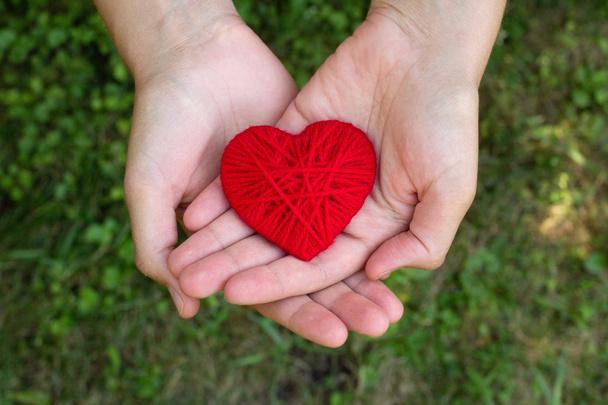 corazón de lana roja en una mano humana, día de San Valentín, amor
 - Foto, imagen