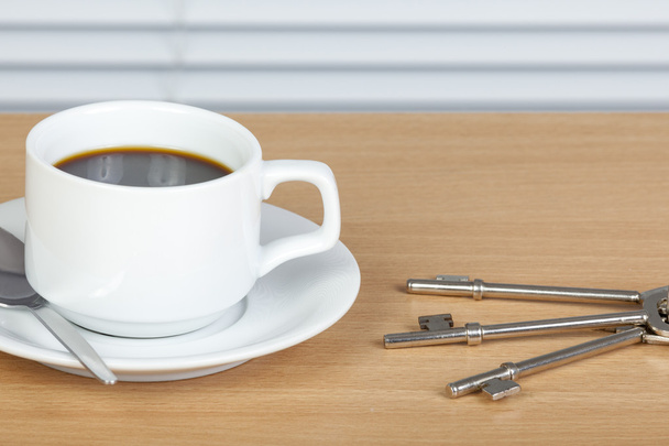 Taza de café en la mesa con un juego de llaves
 - Foto, imagen