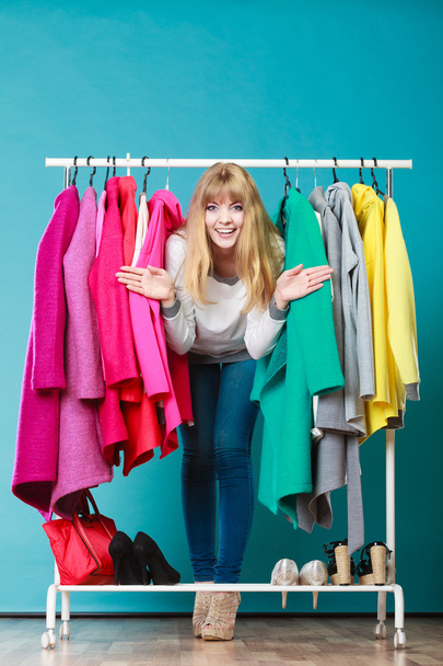 Mujer colándose entre la ropa en el centro comercial o armario
. - Foto, imagen