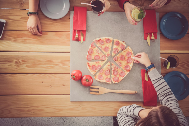Group of people eating pizza. - Zdjęcie, obraz