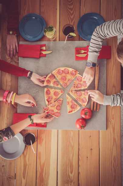 Group of people eating pizza. - 写真・画像