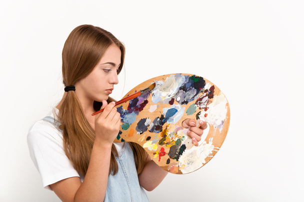 pretty young artist holding a palette and brushes - Photo, Image